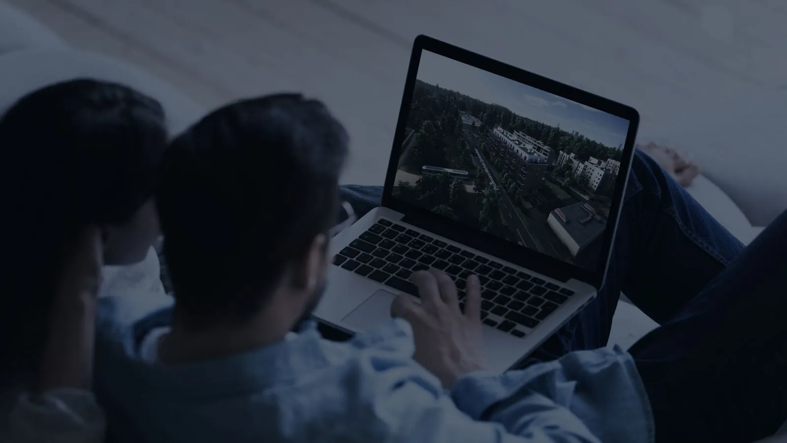 A couple looking at a development in the 3D web application on a laptop